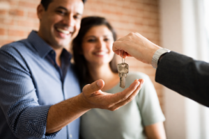 Couple receiving house keys after making an offer on a home in Australia