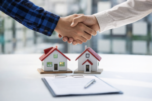 Handshake between mortgage professional and client with model homes, representing trusted mortgage companies in Melbourne