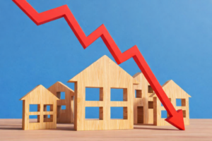 Wooden house models with a downward red arrow representing falling property prices and interest only home loan risk in Australia.