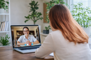 Woman speaking with a mortgage broker via video call on a laptop during an online home loan pre-approval consultation.
